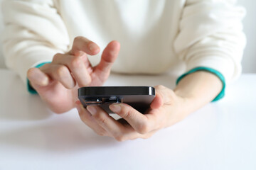 スマートフォンを見る女性の手元