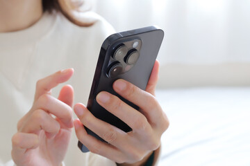 スマートフォンを見る女性の手元