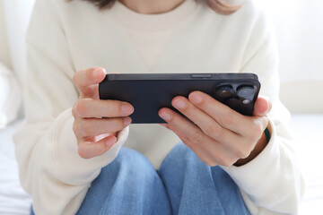 スマホで動画を見る女性