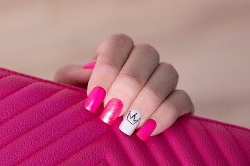 Beautiful female hand with pink manicure nails, crown design