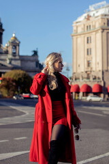 
Stylish blonde hair woman in red coat walking on the street