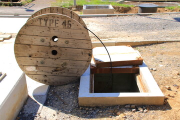 Kabel wird von einer Kabelrolle in einen Schacht gezogen