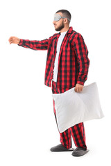 Male sleepwalker in pajamas with pillow on white background