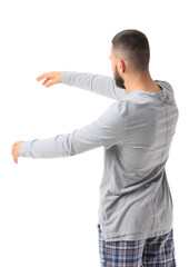 Male sleepwalker in pajamas on white background, back view