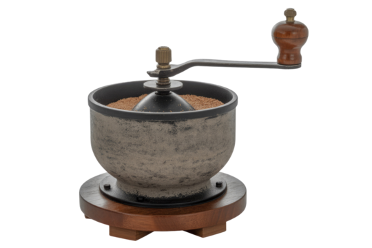 A vintage hand grinder featuring a textured metal bowl, wooden base, and crank, filled with ground material on a plain transparent background. background removed