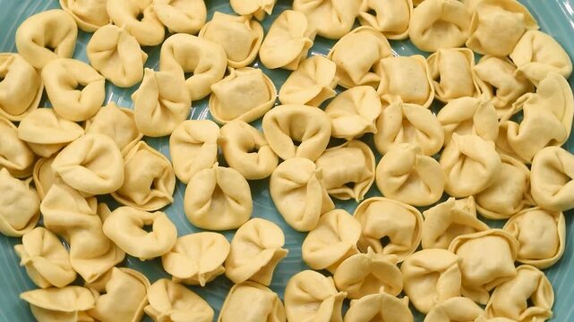 Rotating close-up video of Italian Cappelletti egg pasta filled with meat, showing detailed texture and shape, representing authentic Italian cuisine, culinary tradition, and Mediterranean gastronomy.