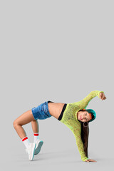 Female hip-hop dancer on light background