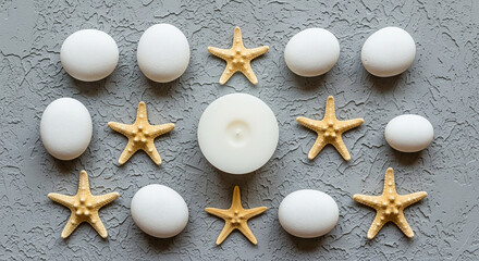 Zen composition of white stones, starfish, and a candle on a textured gray background, promoting relaxation and tranquility