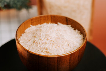 Long grain white rice in a wooden bowl on a simple table