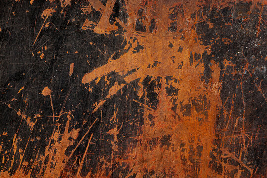 Dark, grungy close-up of a heavily rusted metal surface, jagged patches of vibrant, textured orange-brown rust, black base, fine scratches, raw, industrial, and abstract background, decay