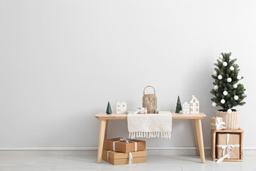 Interior of light room with Christmas tree, table and presents
