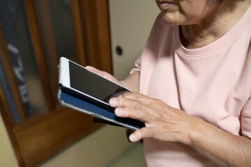 タブレットを操作する高齢女性
