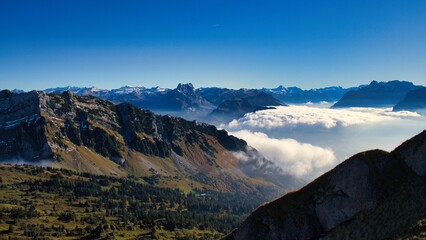 Autumn hike above the sea of ​​fog to Mount Speer. Beautiful views above the fog of the surrounding mountains. Fantastic mountain scenery in Switzerland. Wanderlust. High quality photo.