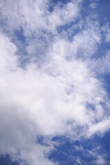 Obraz premium Fluffy White Clouds Against a Vibrant Blue Sky.