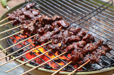 Satay goat satay, lamb, lamb or meat goat satay in grilling place with smoke by people with yummy looking.