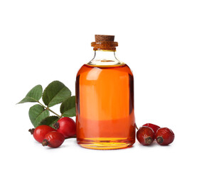 Bottle of cosmetic rose hip oil and berries on white background