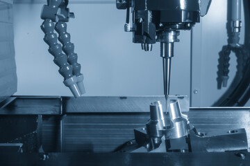 The 5-axis CNC milling machine  cutting the aluminum automotive part with indexable tool in the light blue tone.