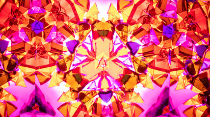 Natural macro kaleidoscope pattern photographed with a camera, showing vibrant abstract geometric shapes in pink, purple, and yellow.