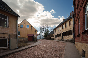 Cobblestone Street with Retro Lantern and Historic Buildings in Kandava Old Town