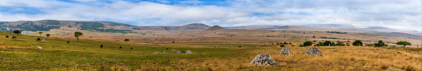 Fototapeta premium A panorama view past burial cairns across the battlefield at Isandlwana in South Africa in Springtime