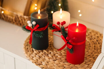 Burning candles with Christmas branches on shelf in room, closeup