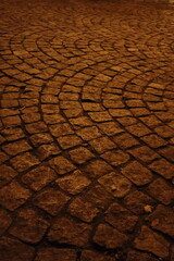 Warmly Lit Cobblestone Pavement at Night