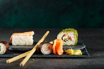 Vielfältige Sushi-Auswahl auf einer dunklen Schieferplatte