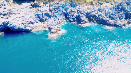 Blue Water Meets Rocky Coastline in a Serene Coastal Scene Captured on a Sunny Day
