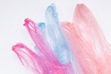 Three multi-colored transparent plastic bags with handles on a white background. Packaging material...