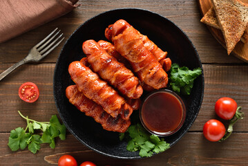 Bacon wrapped sausages with barbecue sauce