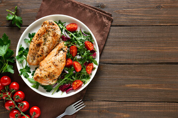 Baked chicken breast and vegetable salad on plate