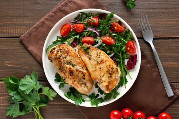 Baked chicken breast and vegetable salad on plate