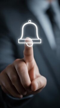 Businessman touching bell icon, representing notification, reminder, alert, attention, updates and important communication in digital business, workplace or corporate environments. Vertical video.