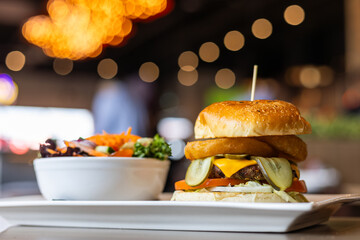 Gourmet Cheeseburger with Onion Rings and Pickles Served with Fresh Salad