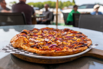 Fresh Barbecue Chicken Pizza Served Outdoors on a Sunny Patio