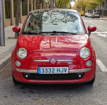 Vista frontal de un autom&oacute;vil Fiat 500 de color rojo aparcado en una calle de Madrid, Espa&ntilde;a, 24 de octubre de 2025