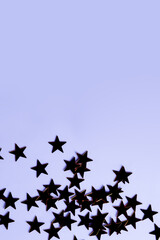Star-shaped sequins silhouettes on purple background, top view, copy space for festive design.