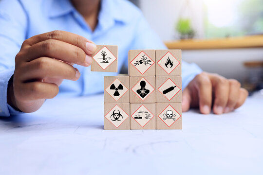 MSDS material safety data sheet concept with staff hand arrange wooden block for dangerous sign to warning staff working on storage site