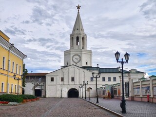 The Spasskaya Tower, main gate of the Kazan Kremlin,a white tower with a clock on it and a tall...