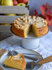 Slice of homemade apple cake with fresh apples and rustic background