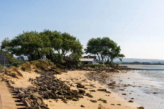 Studland, UK - July 25th 2025: Small sandy beach on the shore of Poole Harbour.