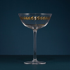 crystal cocktail glass with gold geometric detailing on dark background, perfect for luxury tableware, fine dining, elegant entertaining, interior styling, and product photography