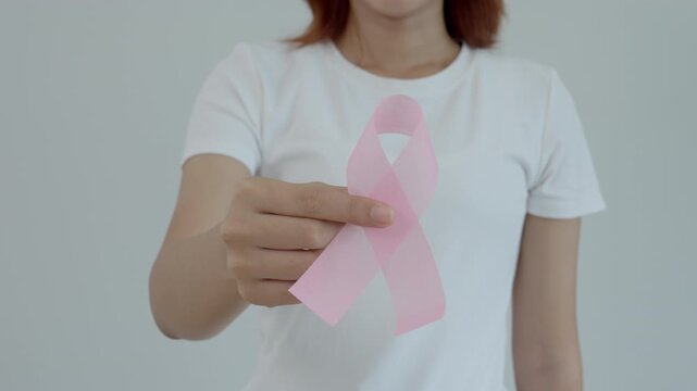 Woman hold pink ribbon breast cancer awareness. Female health check consciousness. international Women Day and World Cancer Day. sign cancer, Symbolic, health care, support patients, timely diagnosis - Powered by Adobe