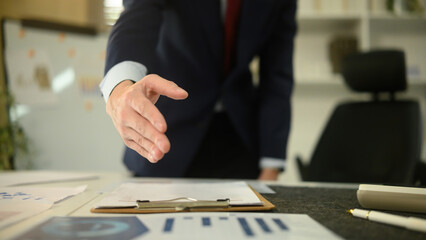Close-up of a businessman extending his hand for a handshake, symbolizing partnership, trust, and successful agreement