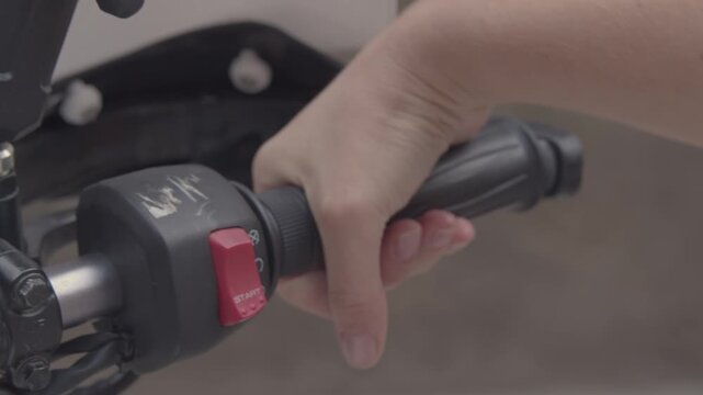 A girl on a motorcycle. A girl sits on an adventure motorcycle during the day, holding the handlebars with bare hands and twisting the throttle.