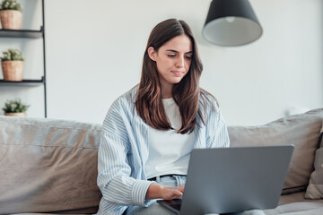 Angry young woman sit on sofa in living room frustrated having operational problems working on laptop, mad millennial girl feel stressed confused with slow internet connection or computer spam
