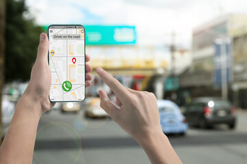 Man using app on mobile phone to call taxi on city street, closeup