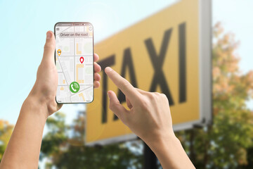 Man using app on mobile phone to call taxi on city street, closeup © New Africa