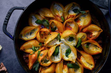 Traditional Italian conchiglioni pasta beautifully arranged on a rustic background. A classic taste of Italy captured in a warm and inviting food scene — perfect for authentic cuisine, restaurant menu