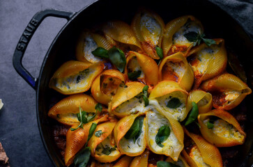 Traditional Italian conchiglioni pasta beautifully arranged on a rustic background. A classic taste of Italy captured in a warm and inviting food scene — perfect for authentic cuisine, restaurant menu